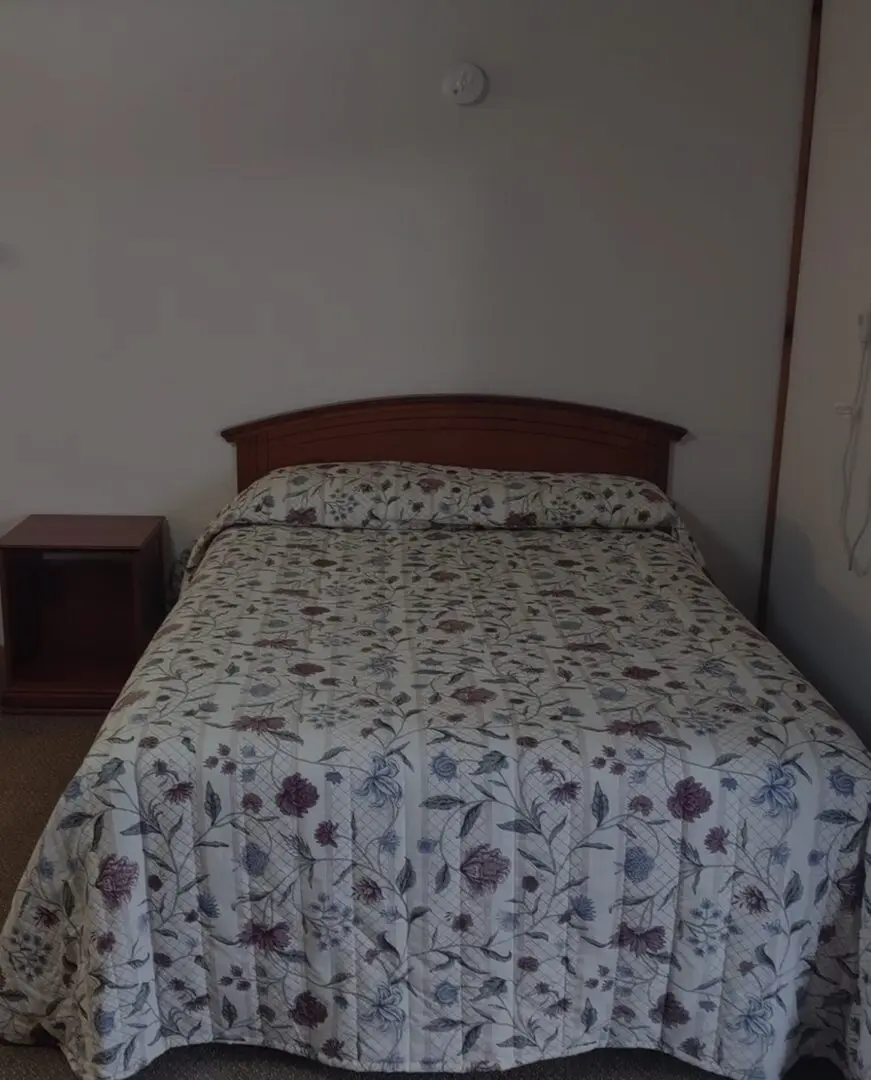 Cozy bedroom with floral-patterned blanket.
