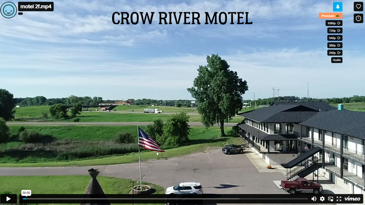 Crow River Motel exterior with flag and fields